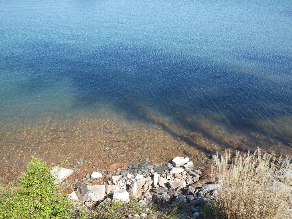 Clear, shallow water over a rocky Lake Keowee shoreline.
